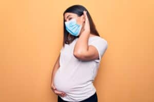 אישה בהריון עם מסכה בודקת שמיעה